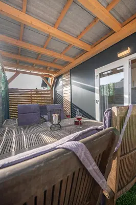 a patio with a table and chairs on a deck at Hiškovec - Holiday Village in Trebnje