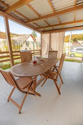 a wooden table and chairs on a patio at Hiškovec - Holiday Village in Trebnje
