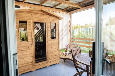 a wooden shed with a table and chairs on a patio at Hiškovec - Holiday Village in Trebnje