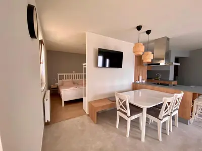 a kitchen and dining room with a white table and chairs at Apartma Lastovka in Bled