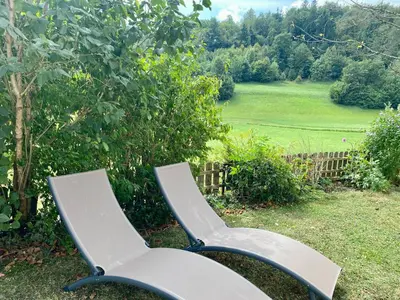 a bench sitting in the grass in a yard at Apartma Lastovka in Bled