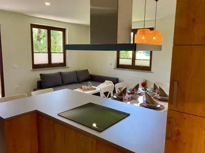 a kitchen and living room with a couch and a table at Apartma Lastovka in Bled