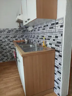 a kitchen with a sink and a tile wall at Apartment ML FREE PARKING in Loče pri Poljčanah
