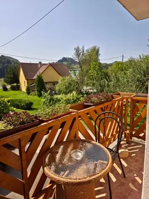 a wooden deck with a table and a chair at Apartment ML FREE PARKING in Loče pri Poljčanah
