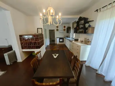 a dining room with a table and a kitchen at Hiša Hortenzija Luče in Luče