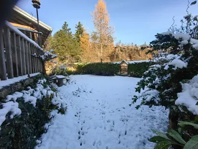 a yard covered in snow next to a house at Hiša Hortenzija Luče in Luče