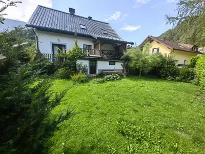 a house with a green lawn in front of it at Hiša Hortenzija Luče in Luče