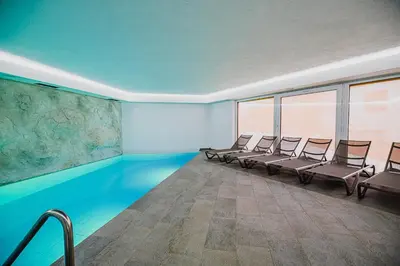 a row of chairs in a room with a swimming pool at Glamping Maleric with Natural Pool in Dragatuš