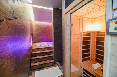 a bathroom with a tub in a room with wooden walls at Glamping Maleric with Natural Pool in Dragatuš