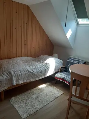 a bedroom with a bed and a table in a attic at Encijan in Bohinj