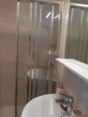 a white bathroom with a sink and a shower at Encijan in Bohinj