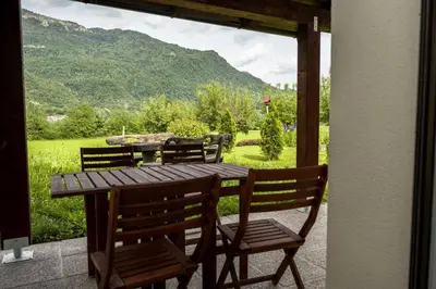 a wooden table and chairs with a view of a mountain at Hiša Krn in Kobarid