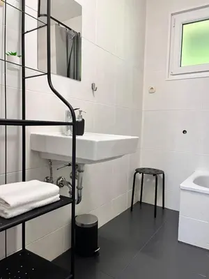 a white bathroom with a sink and a mirror at Hiša Krn in Kobarid