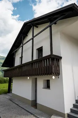 a white building with a balcony on the side at Hiša Krn in Kobarid