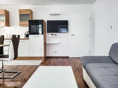 a living room with a couch and a kitchen at Stara Pošta Apartment 7 in Grosuplje