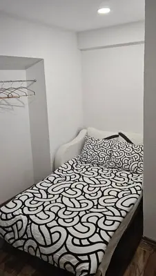 a bed with a black and white comforter in a room at Stara Pošta Apartment 7 in Grosuplje