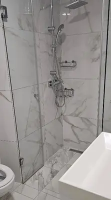 a shower with a glass door in a bathroom at Stara Pošta Apartment 7 in Grosuplje