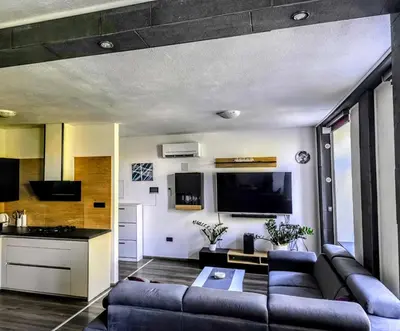 a living room with a couch and a tv at Central Ljubljana Apartment in Ljubljana