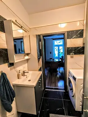 a bathroom with a sink and a washing machine at Central Ljubljana Apartment in Ljubljana