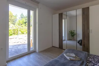 a bedroom with a bed and a sliding glass door at Apartma Matevž in Radovljica