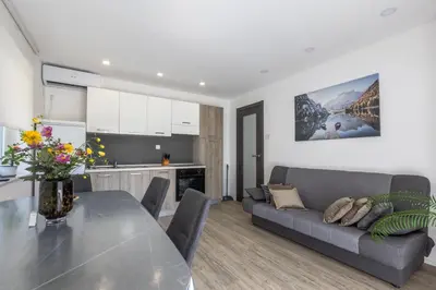 a kitchen and a living room with a table and a couch at Apartma Matevž in Radovljica