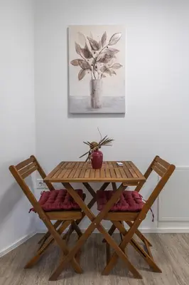 a wooden table with two chairs and a plant on it at Apartma Matevž in Radovljica