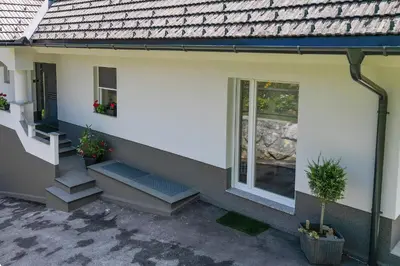 a white house with stairs and a window at Apartma Matevž in Radovljica