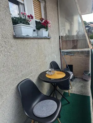 a small patio with two chairs and a table at Studio apartman DINO z balkonom in Rogatec