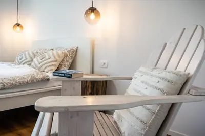 a room with a bench and a bed with pillows at Hidden Corner in Žirovnica