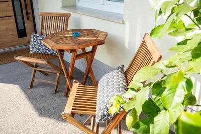 a wooden table and chairs on a patio with a table at Hidden Corner in Žirovnica
