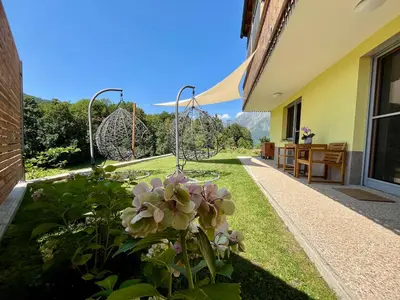 a garden with pink flowers in a yard at Cozy & Chic - Apartment with a private patio in Kobarid