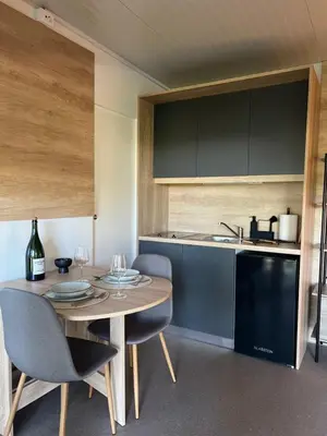 a kitchen with a wooden table and chairs and a counter at ChillHouse in Ajdovščina
