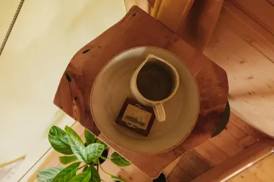 a cup of coffee and a piece of cake on a table at Lakeside Glamping Tents Mažijev Grič in Gradišče pri Lukovici