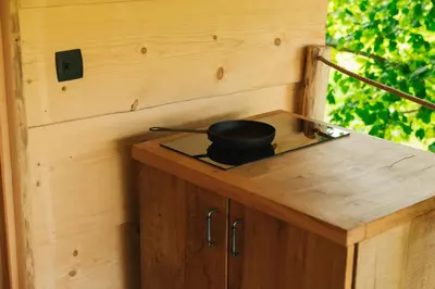a black pot sitting on top of a wooden cabinet at Lakeside Glamping Tents Mažijev Grič in Gradišče pri Lukovici