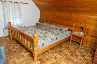 a bedroom with a bed with a wooden wall at Apartmaji Lipa in Bohinj