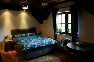 a bedroom with a bed and a table and a window at Apartmaji Lipa in Bohinj