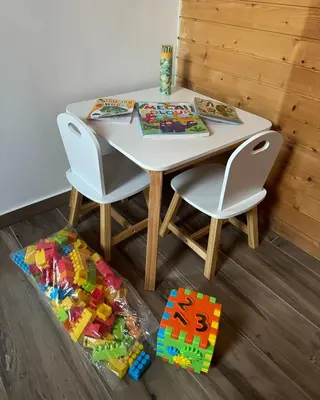a white table with two chairs and a lego toy on the floor at Apartmaji Lipa in Bohinj