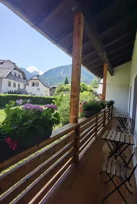 a porch with a wooden fence and flowers at Apartma Žerjav in Kranjska Gora