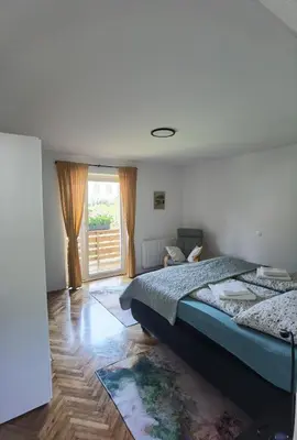 a bedroom with a bed and a large window at Apartma Žerjav in Kranjska Gora