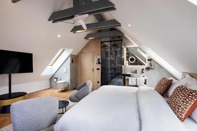 a bedroom with a large white bed and chairs at Hotel Julian Alps in Zgornje Gorje