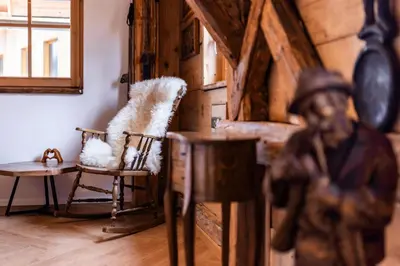 a room with wooden furniture and a chair and a window at Hotel Julian Alps in Zgornje Gorje