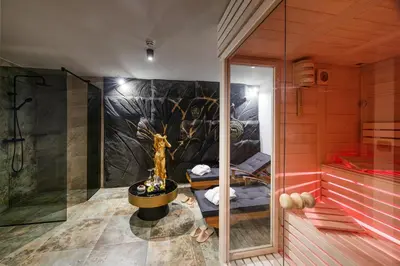 a bathroom with a shower with a tree mural at Hotel Julian Alps in Zgornje Gorje