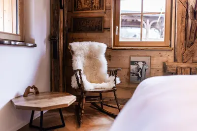 a room with a chair and a table and a window at Hotel Julian Alps in Zgornje Gorje