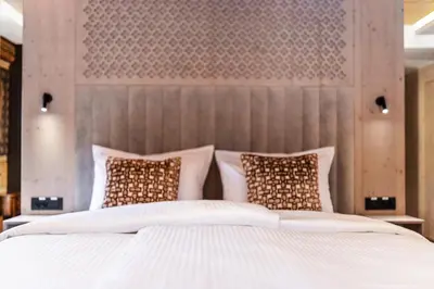 a bedroom with a large bed with white sheets and pillows at Hotel Julian Alps in Zgornje Gorje