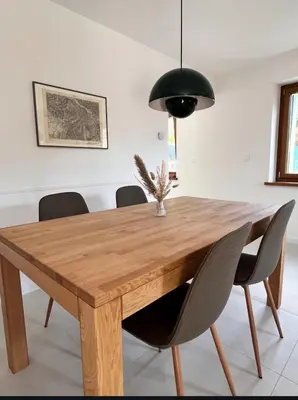 a dining room table with chairs and a black lamp at Up and above in Kobarid