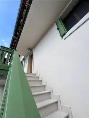 a staircase leading to a building with a green window at Up and above in Kobarid