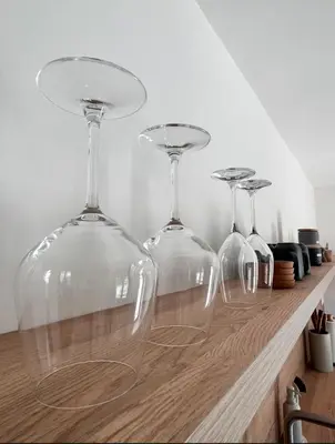 three wine glasses sitting on top of a counter at Up and above in Kobarid
