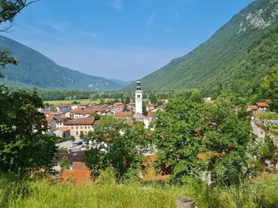 a town in the mountains with a clock tower at Up and above in Kobarid