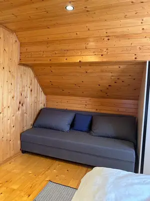 a bed in a room with a wooden ceiling at Wooden Cottage Baznik with Hot Tub in Cerklje ob Krki