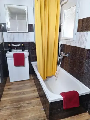 a bathroom with a yellow shower curtain and a tub at Rural Retreat- Kmečki oddih in Poljčane